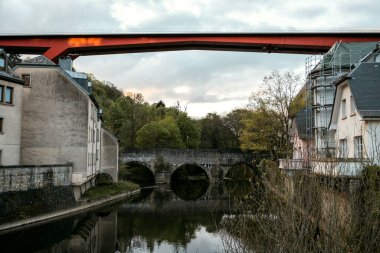 Lüksemburg 'daki Old Town' un Grund mahallesinde arka planda kırmızı Grandüşes Charlotte Köprüsü var. Lüksemburg 'un Pfaffenthal ilçesi Lüksemburg Grandükü' nün başkentidir.