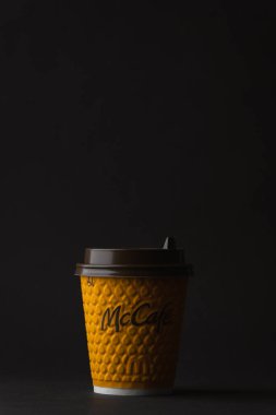 KYIV, UKRAINE - Ocak 06: Popüler bir fast food restoranında sarı McDonald 's kağıt bardakta kahve yakın çekim. McDonalds 'dan McCafe kahve fincanı, siyah arka planda.