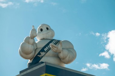 Madrid, İspanya - 16 Şubat 2024: Michelin Man Fransız lastik üreticisinin resmi maskotu beyaz bulutlu mavi gökyüzüne karşı