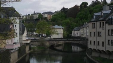Eski Avrupa şehrinde günbatımı Lüksemburg Büyük Dükalığı 'nın başkentidir. Burgundy kırmızı gökyüzü, Lüksemburg 'un Eski Kasaba' nın Grund semtindeki Alzette nehrinin suyuna yansıyor.