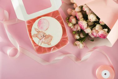 Bebek partisi parti bento keki ve yanında bir buket çiçeğin yanında beyaz çikolatalı pasta. Gelecek çocuğun cinsiyetini tahmin et. Yeni doğmuş bir bebek için küçük bir bento keki. Pembe arkaplan