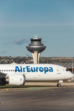 Madrid, İspanya - 2 Şubat 2024: Büyük yolcu Boeing 787-900 hayali uçak Air Europa havayolları güneşli havada Madrid-Barajas Havaalanı 'ndan ayrılmadan önce hava trafik kontrol kulesinden vergi indiriyor