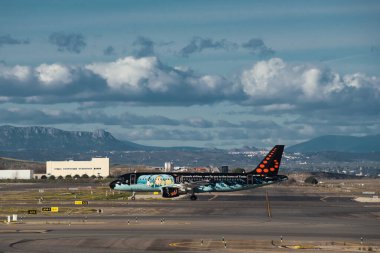 Madrid, İspanya - 2 Şubat 2024: Güneşli bir günde Madrid-Barajas Havalimanı 'nda Hava Trafik Kontrol Kulesi' nden Tintin çizgi romanlarıyla yüklü büyük yolcu Airbus A320 uçağı.
