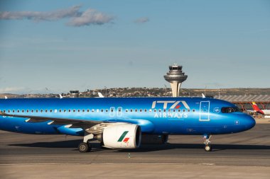 Madrid, İspanya - 12 Şubat 2024: Büyük Yolcu Airbus A320-272N ITA Airways uçakları güneşli bir günde Madrid-Barajas Havalimanı 'ndan kalkmadan önce mavi üniformalı havayolları.