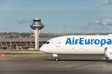 Madrid, İspanya - 2 Şubat 2024: Büyük yolcu Boeing 787-900 hayali uçak Air Europa havayolları güneşli havada Madrid-Barajas Havaalanı 'ndan ayrılmadan önce hava trafik kontrol kulesinden vergi indiriyor