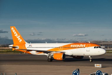 Madrid, İspanya - 12 Şubat 2024: Güneşli bir günde Madrid-Barajas Havalimanı 'ndan kalkmadan önce ağır yük taşıyan A320-214 adet kolay jet uçağı.