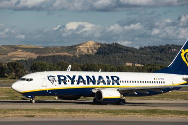 Madrid, İspanya - 2 Şubat 2024: Güneşli bir günde Madrid-Barajas Havaalanı 'ndaki hava trafik kontrol kulesinin yanında düşük maliyetli Ryanair Airlines' ın büyük yolcu uçağı Boeing 737-8AS