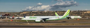 Madrid, İspanya - 12 Şubat 2024: Güneşli bir günde Madrid-Barajas Havaalanı 'ndan ayrılmadan önce Binter Canarias Havayolları' nın yolcu Embraer E195-E2 uçağının panoramik görüntüsü.