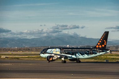 Madrid, İspanya - 2 Şubat 2024: Güneşli bir günde Madrid-Barajas Havalimanı 'nda Hava Trafik Kontrol Kulesi' nden Tintin çizgi romanlarıyla yüklü büyük yolcu Airbus A320 uçağı.