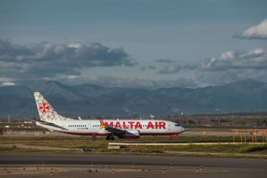 Madrid, İspanya - 12 Şubat 2024: Büyük Yolcu Boeing 737 MAX 8-200 Malta Hava Yolları uçağı güneşli bir günde Madrid-Barajas Havalimanı 'ndan kalkmadan önce vergi indiriyor.
