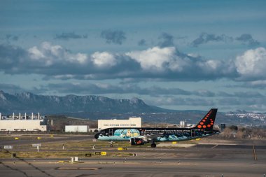 Madrid, İspanya - 2 Şubat 2024: Güneşli bir günde Madrid-Barajas Havalimanı 'nda Hava Trafik Kontrol Kulesi' nden Tintin çizgi romanlarıyla yüklü büyük yolcu Airbus A320 uçağı.