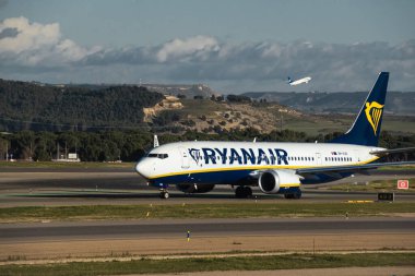 Madrid, İspanya - 2 Şubat 2024: Büyük yolcu Boeing 737 MAX 8-200 düşük maliyetli Ryanair Airlines uçağı güneşli bir günde Madrid-Barajas Havaalanı 'ndaki dağlara vergi indiriyor