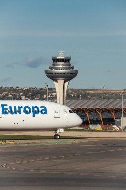 Madrid, İspanya - 2 Şubat 2024: Büyük yolcu Boeing 787-900 hayali uçak Air Europa havayolları güneşli havada Madrid-Barajas Havaalanı 'ndan ayrılmadan önce hava trafik kontrol kulesinden vergi indiriyor