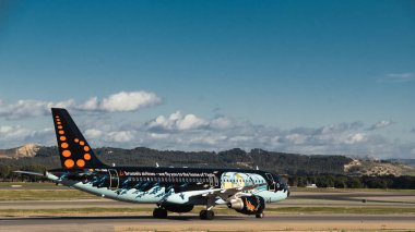 Madrid, İspanya - 2 Şubat 2024: Güneşli bir günde Madrid-Barajas Havalimanı 'nda Hava Trafik Kontrol Kulesi' nden Tintin çizgi romanlarıyla yüklü büyük yolcu Airbus A320 uçağı.