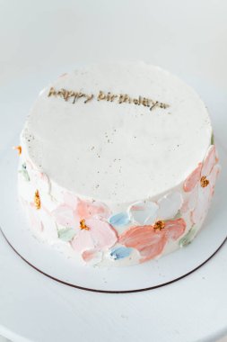 Renkli krem peynirli çiçeklerle süslenmiş beyaz çikolatalı güzel bir pasta. Beyaz arkaplan