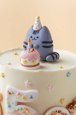 Kyiv, Ukrayna - 26 Ekim 2024: Çizgi film kedisi Pusheen biblosunun üzerine şekerli çörek ile süslenmiş kek. Bej arka planda beş yaşındaki küçük bir kız için doğum günü pastası.