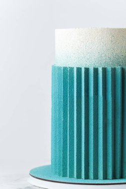 Güzel yıldönümü ya da uzun düğün pastası. Beyaz arka planda çikolata turkuazlı tırtıklı.