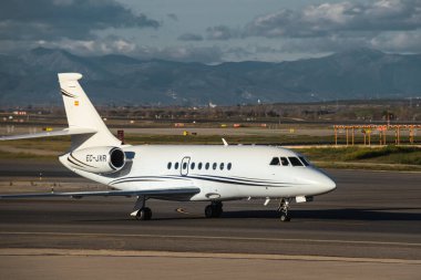 Madrid, İspanya - 2 Şubat 2024: Lüks Dassault Falcon 2000 iş jet uçağı Gestair Havayolları 'nın güneşli bir günde Madrid-Barajas Havaalanı' ndaki Hava Trafik Kontrol Kulesi yakınlarında vergi indiriyor