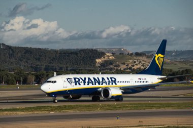 Madrid, İspanya - 2 Şubat 2024: Büyük yolcu Boeing 737 MAX 8-200 düşük maliyetli Ryanair Airlines uçağı güneşli bir günde Madrid-Barajas Havaalanı 'ndaki dağlara vergi indiriyor