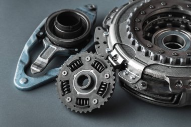 DSG 'nin otomatik vites kutusunun yeni debriyaj takımı yenilenmeye hazır. Gri arka planda izole edilmiş modern bir araba için yedek parça. Araba tamiri ve servis konsepti