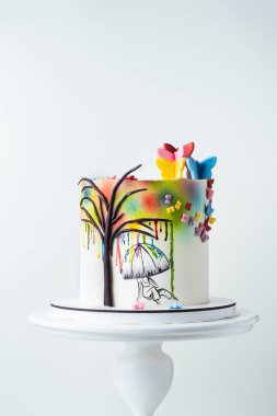 Beyaz arka plandaki bir sanatçı için güzel bir doğum günü pastası. Renkli yağmur boyalarıyla süslenmiş beyaz çikolatalı pasta. Ressam ya da sanatçı konsepti pastası