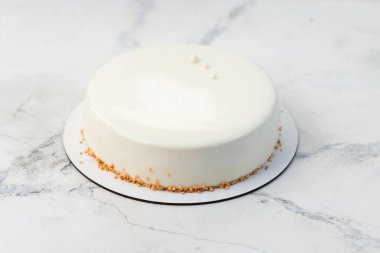 Kurutulmuş waffle kırıntılarıyla süslenmiş ve pürüzsüz çikolata jöleli sade beyaz kremalı pasta. Beyaz mermer arkaplan