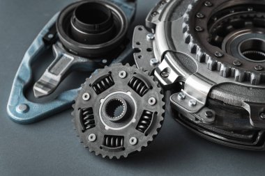 DSG 'nin otomatik vites kutusunun yeni debriyaj takımı yenilenmeye hazır. Gri arka planda izole edilmiş modern bir araba için yedek parça. Araba tamiri ve servis konsepti