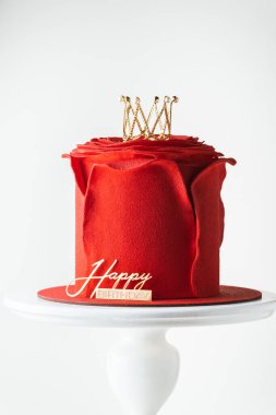 Güzel kraliçe ya da prenses temalı kırmızı pasta ve çiçek şeklinde gül yaprakları. Kırmızı kadife kaplamalı, altın taçla süslenmiş lüks gül şekilli doğum günü pastası. Beyaz arkaplan