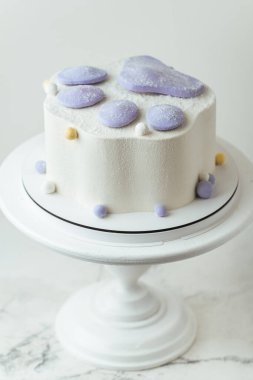 Beyaz arka planda modaya uygun, yumuşak, yumuşak bir pençe şeklinde doğum günü pastası. Beyaz krem peynirli kremalı bir çocuk için Taba pençesi şeklinde pasta.