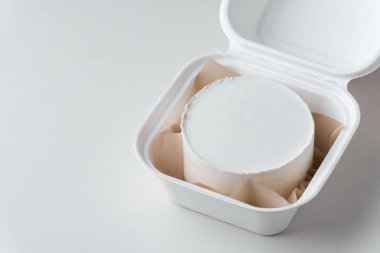 Süssüz beyaz bento keki içinde kahverengi kağıt olan bir hediye kutusunda. Beyaz mermer arka planda kendi dekorasyonunuz için boş bir alanı olan kek modeli