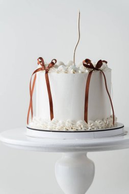 Krem şantili krem peynirli nefis Lambeth tarzı kek. Beyaz arka planda altın mumla süslenmiş yumuşak doğum günü pastası.