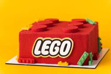 Kyiv, Ukrayna - 14 Mayıs 2025: Sarı arka planda çikolata kadife kaplamalı kırmızı lego tuğlası şeklinde doğum günü pastası.