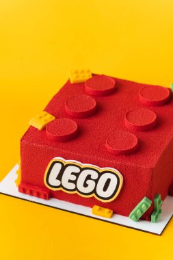 Kyiv, Ukrayna - 14 Mayıs 2025: Sarı arka planda çikolata kadife kaplamalı kırmızı lego tuğlası şeklinde doğum günü pastası.
