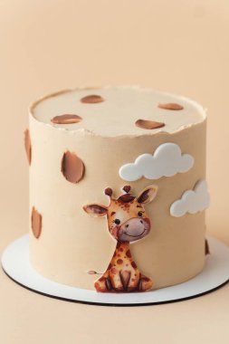 Beyaz arka planda yenilebilir zürafayla süslenmiş bej çikolatalı şirin Afrika tarzı doğum günü pastası..