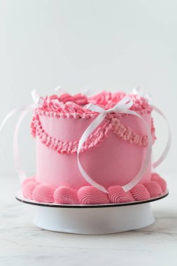 Zarif Lambeth tarzı doğum günü pastası pembe krem peynirli krem şantili süslemeli ve üstünde doğum günü mesajı olan. Beyaz arkaplan