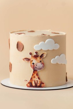 Beyaz arka planda yenilebilir zürafayla süslenmiş bej çikolatalı şirin Afrika tarzı doğum günü pastası..