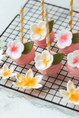 Çocukların doğum günü partisi için çikolatalı şeker. Çiçeklerle süslenmiş lezzetli pembe buzlu dondurma. Düğün süslemeleri.