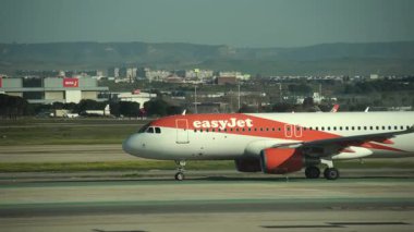 Madrid, İspanya - 12 Şubat 2024: Güneşli bir günde Madrid-Barajas Havalimanı 'nda uçan yumuşak jet havayolu A320-214 numaralı Airbus' a gelen büyük yolcu.