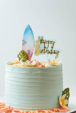 Yenebilir sörf tahtası kumuyla süslenmiş turkuaz krem peynirli doğum günü pastası ve mutlu yıllar. Bir sörfçü için doğum günü pastası. Yaz tatilleri ve tropikal tatil konsepti
