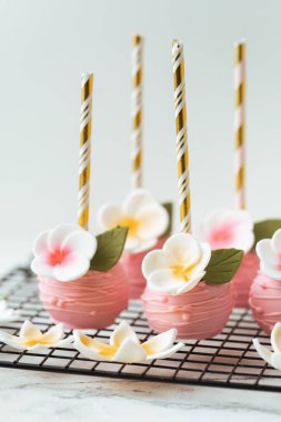 Çocukların doğum günü partisi için çikolatalı şeker. Çiçeklerle süslenmiş lezzetli pembe buzlu dondurma. Düğün süslemeleri.