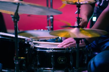 Bateristin ellerine ve zillerine odaklanmış bir davul seti. Seçici odak.