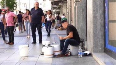Madrid, İspanya - 17 Eylül 2022: Gran Via 'da plastik kova ve tencere ve tavalarla davul çalan sokak müzisyeni