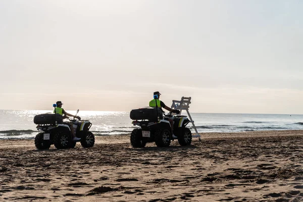 stock image Oliva, Spain - August 28, 2022: Two police officers patrol deserted beach at dawn in Valencia. Oliva Nova Beach