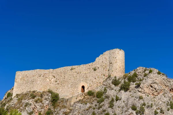 Medieval castle on top of hill against blue sky. Castle of Los Rojas In Pozas de la Sal.