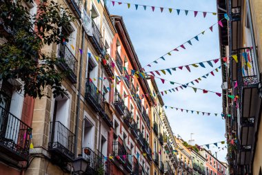 Street decorated with pennants hanging from the facades in the traditional neighborhood of Embajadores in Madrid