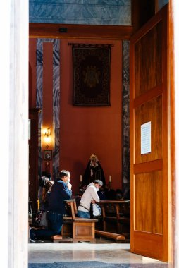 Madrid, Spain - October 11, 2020: The Faithful praying on their knees inside St. Andrew Church.