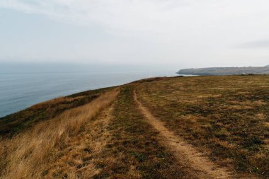 Ajo, Trasmiera, Cantabria, İspanya 'daki Antuerta plajını çevreleyen kayalıklar. Sahilde çarpıcı bir manzaranın içinden geçen bir yürüyüş yolu var..