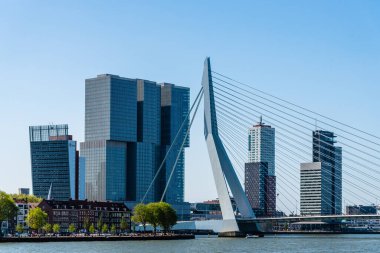 Rotterdam, Hollanda - 8 Mayıs 2022: De Rotterdam Gökdeleni Rem Koolhaas tarafından tasarlandı ve Erasmusbrug Köprüsü gökyüzüne karşı inşa edildi. Çağdaş mimari.