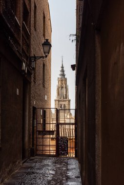 Toledo, İspanya - 19 Şubat 2023 Toledo Katedrali 'nin ortaçağ şehrindeki dar bir ara sokağa bakan görüntüsü.