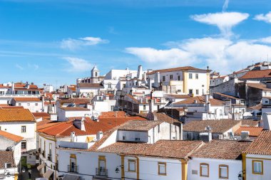 Evora, Portekiz - 30 Haziran 2022: Evora şehri beyaz ve seramik kiremitli çatılarla boyanmış tipik evler. Alentejo, Portekiz